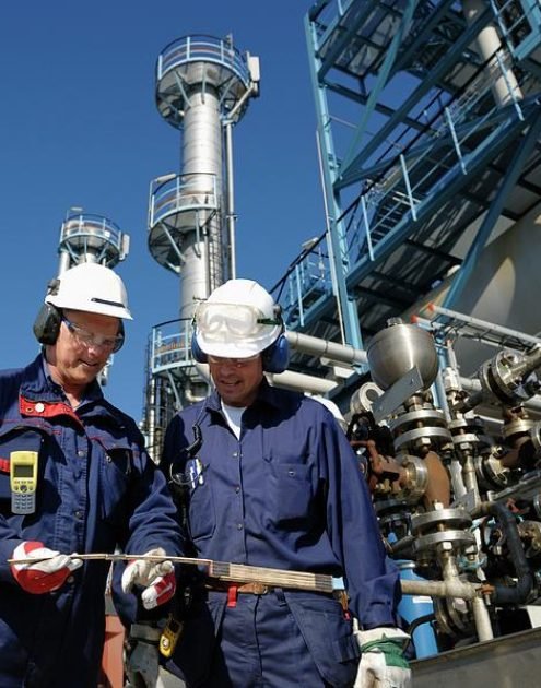 oil-refinery-workers-and-pipework-christian-lagerekscience-photo-library